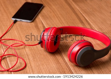 Smartphone and headphones on a rustic wooden table. Top view with copy space