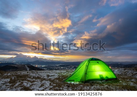 Tent on the top of the mountain against the backdrop of the sunset