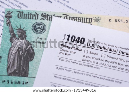 US Treasury stimulus check laying on a form 1040 tax return for 2020 to illustrate questions about qualification for payment Royalty-Free Stock Photo #1913449816