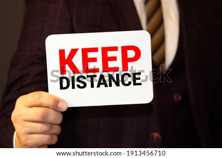 Text - keep distance. Top view written on white paper on a desktop. Medical concept.