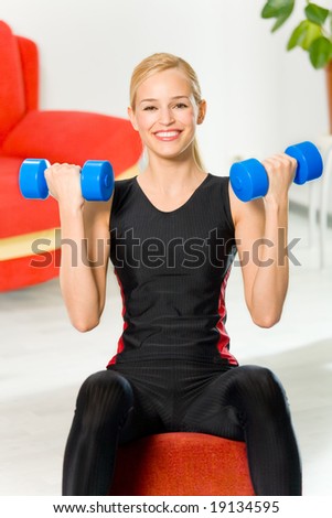 Young happy woman doing fitness exercises at home