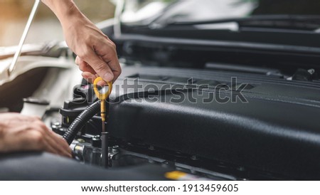 Close up of hands checking the oil level in the engine before a trip or journey, Car check condition concept. Royalty-Free Stock Photo #1913459605