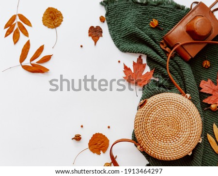 Creative autumn flat lay with rattan modern bag and old retro camera, blogger concept