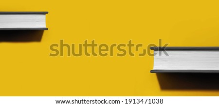 two books in gray hardcover with white blank sheets with hard trend shadow on bright Illuminating yellow background, book day 2021 concept, colors of year application, selective focus Royalty-Free Stock Photo #1913471038