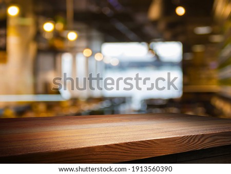 wooden table for placing products with a beautiful night restaurant backdrop, Space for placing items on the table, product and food display. Royalty-Free Stock Photo #1913560390