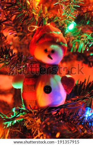 Snowman in the light of Christmas decorations