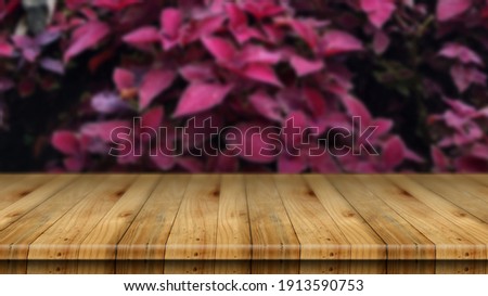 Fence backdrop with wild pink leaves outdoors blurred with wooden table on top - can be used for montage or displaying your product 