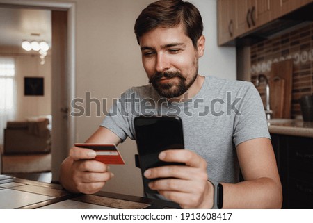 hipster young man shopping online with credit card using smart phone at home. Indoor. online shopping concept.
