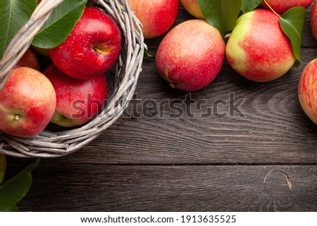 Ripe garden apple fruits in basket on wooden table. Top view flat lay with copy space