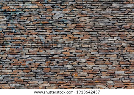 Stone wall background. Old dry stone texture pattern. Dry stacked wall assembled without mortar or cement