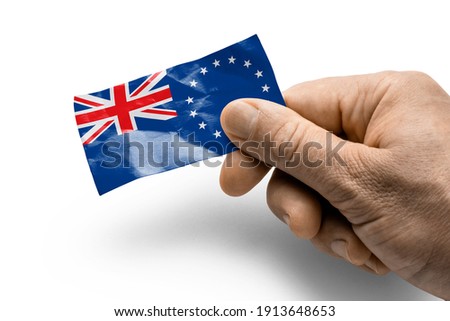 Hand holding a card with a national flag the Cook Islands