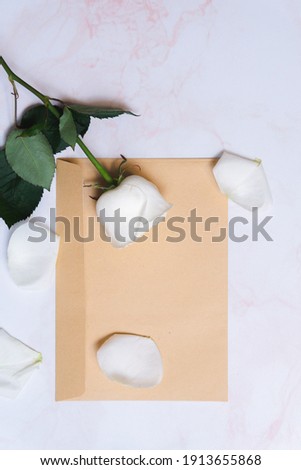 
the rose lies on a paper envelope as a background. valentine's day celebration and eighth march concept