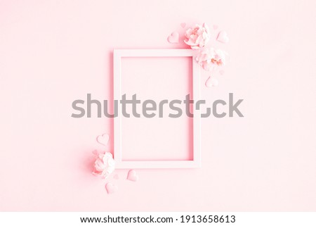 Valentine's Day background. Photo frame, pink flowers, hearts on pastel pink background. Valentines day concept. Flat lay, top view, copy space