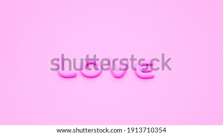 Pink love letters sculpted in plasticine on pink background
