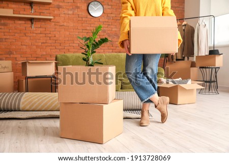Woman with belongings in cardboard boxes on moving day Royalty-Free Stock Photo #1913728069