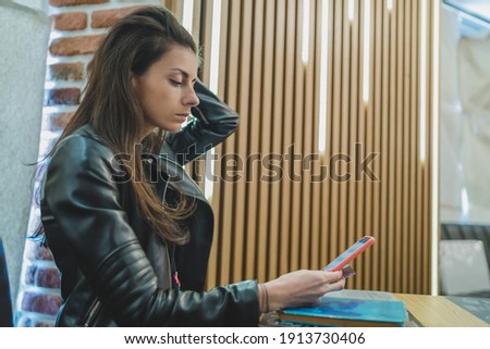 Side view of beautiful woman using smartphone for online shoping in coffee shop