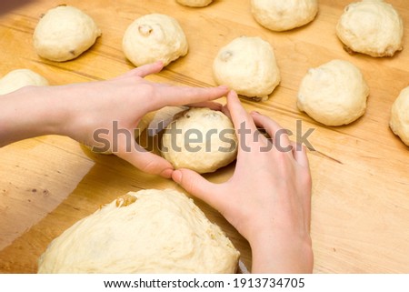 Making dough buns. Women's hands in the shape of a heart. homemade baking