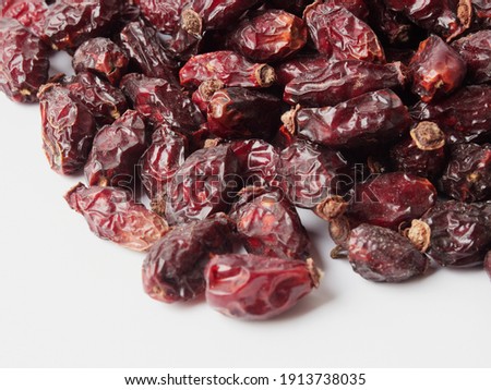 Dried berries of Dog Rose or Rosa canina. Dry fruits of sweet-brier or rose hips on wooden background. Healthy and herbal concept. Selective focus. Natural vitamin, nutritional supplement for health  
