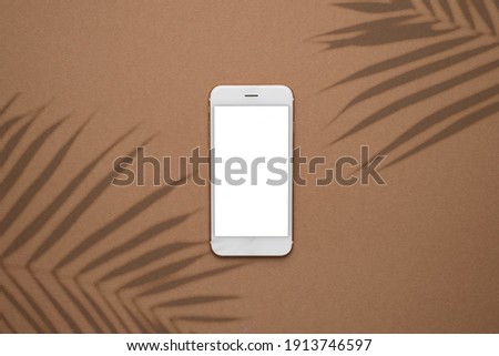 Modern smartphone on pastel colored background. Mock up for game design, mobile application, wallpapers, websites. Plant and shadows top view
