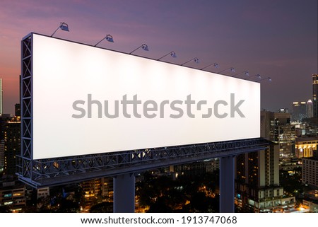 Blank white road billboard with Bangkok cityscape background at night time. Street advertising poster, mock up, 3D rendering. Side view. The concept of marketing communication to sell idea. Royalty-Free Stock Photo #1913747068