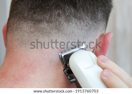 A white male during a fresh shaved hair cut with electric clippers and foils at home in the bathroom.  Royalty-Free Stock Photo #1913760703
