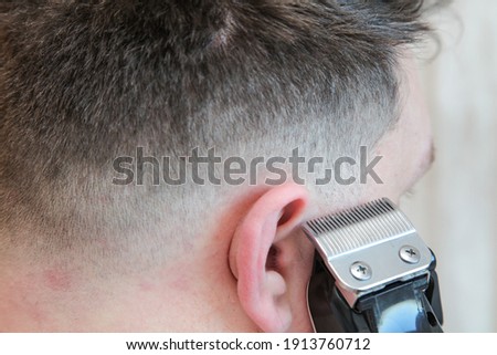 A white male during a fresh shaved hair cut with electric clippers and foils at home in the bathroom.  Royalty-Free Stock Photo #1913760712