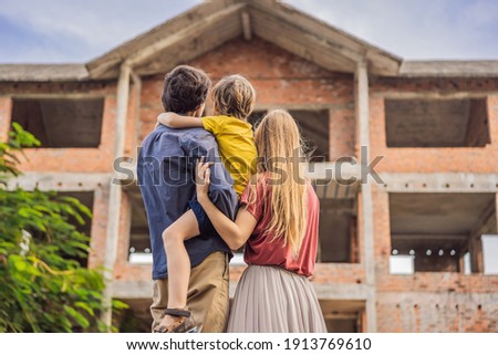 Family mother, father and son looking at their new house under construction, planning future and dreaming. Young family dreaming about a new home. Real estate concept Royalty-Free Stock Photo #1913769610