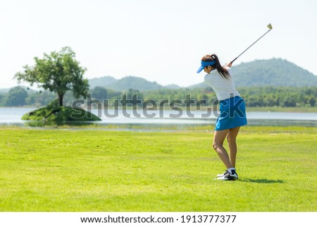 Golfer sport course golf ball fairway. People lifestyle woman playing game golf and hitting go on green grass river and mountain background.  Asia female player game shot in summer.  Healthy  Sport