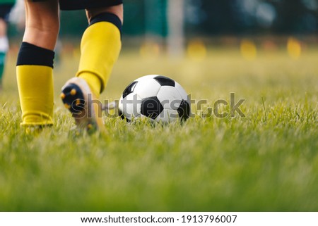 Football Player Running Ball Background. Low Angle Image of Soccer Boy Kicking Ball on Grass Training Field