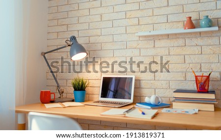 Office workplace with laptop on wooden table.     Royalty-Free Stock Photo #1913819371