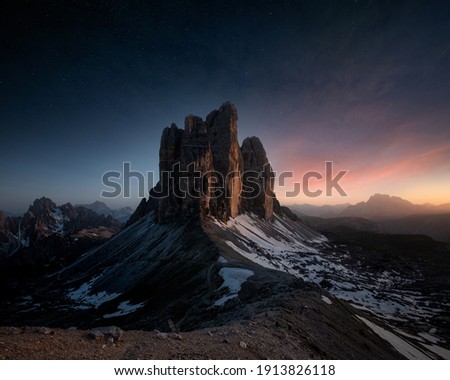 an epic view of Tre Cime Di Lavaredo mountain in sunset with stars on the sky