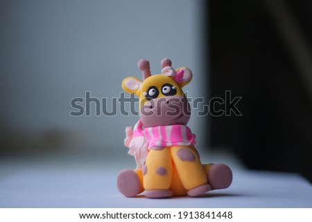 figure funny toy giraffe made of clay by hand and scarf