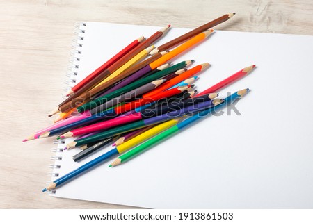 Album with pencils on the table Royalty-Free Stock Photo #1913861503
