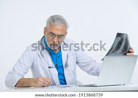 
Senior male doctor analyzing x-ray image in hospital.
