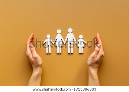 Hands holding family figure top view. Insurance concept