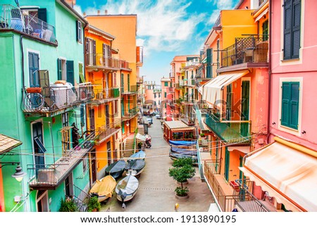Manarola, Liguria Italy. Traditional typical Italian village in National park Cinque Terre, colorful multicolored buildings houses, fishing boats on road, blue cloudy sky Royalty-Free Stock Photo #1913890195