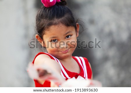 A cute Asian boy or a cute girl holding a red rose or a sweet blooming flower for love on valentine's day or wedding.
