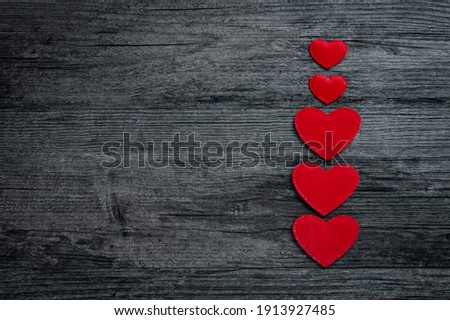 Top view of red heart column on dark old wooden background with copyspace
