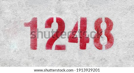 Red Number 1248 on the white wall. Spray paint.