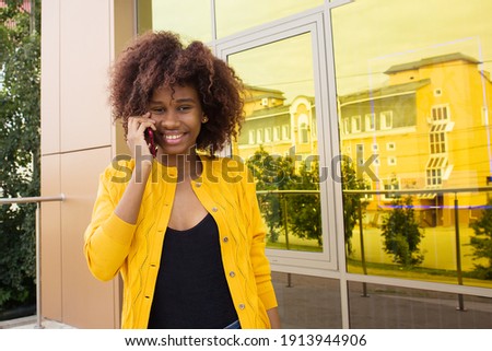 Happy African American woman on the street talking on the phone