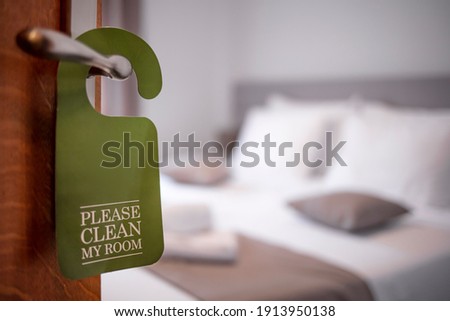 Please make up my room. Maid cleaning the room with please make up my room sign on the door. Opened door of hotel room in morning.Hotel, door open. Clean and elegant accommodation service. 