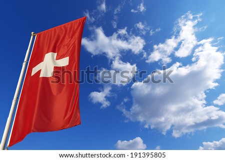 Switzerland Flag in Blue Sky / Flags of Switzerland waving in the wind on blue sky with clouds