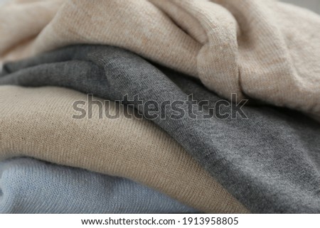Stack of cashmere clothes as background, closeup Royalty-Free Stock Photo #1913958805