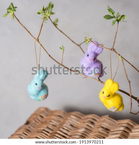 Easter bunnies made of wool on a flowering branch. Wool decor for home decoration