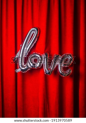 Balloons word love the word love aganist red velor curtain