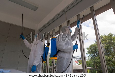 Two professional men wearing suit and spray and clean inside house. window and beautiful city view. background and copy space. Royalty-Free Stock Photo #1913973253