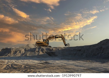 A large excavator working on an industrial site under a sunset sky