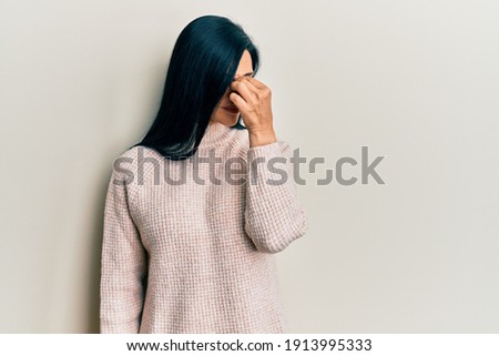 Young caucasian woman wearing casual winter sweater tired rubbing nose and eyes feeling fatigue and headache. stress and frustration concept. 