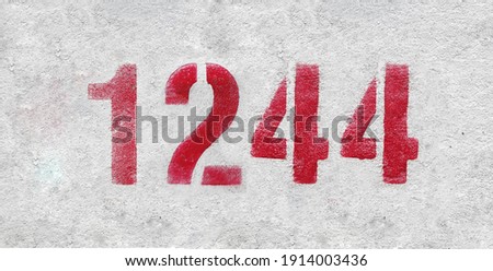 Red Number 1244 on the white wall. Spray paint.