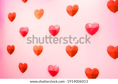 Holiday background for Valentine's Day, Red polygonal paper heart shapes on a cream background. Love concept. Plain. Minimalistic style